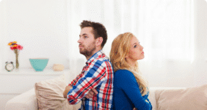 4 vyrų klaidos, griaunančios net stipriausius santykius pora sėdi ant sofos susirėmę nugaromis