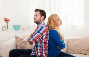 4 vyrų klaidos, griaunančios net stipriausius santykius pora sėdi ant sofos susirėmę nugaromis