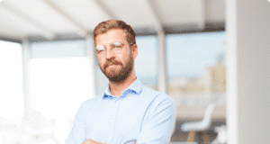 Vidinė lyderystė: kaip tapti savo gyvenimo šeimininku, o ne tironu trisdešimtmetis vyras iš arti stovi sunėręs rankas