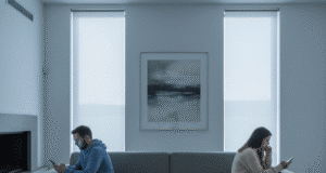 „Kambariokų sindromas“: kai meilė virsta buitimi pora sėdi skirtingose sofos pusėse emociškai atitolę