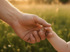 Meilė be sąlygų: kodėl tai svarbiausia dovana Jūsų vaikams? tėčio ranka laiko vaiko rankutę