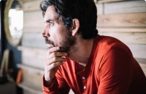 Keturi vyriškumo archetipai: Raktas į brandesnį ir autentiškesnį save vyras sėdi prie namo ir žiūri į tolį