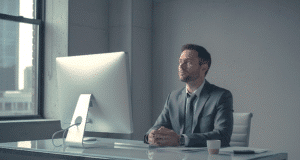 Prarastas ryšys: kodėl jūsų darbas biure atrodo beprasmis? vyras sėdi ofise ir stebeilijasi į ekraną