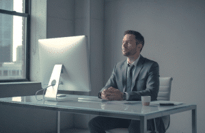 Prarastas ryšys: kodėl jūsų darbas biure atrodo beprasmis? vyras sėdi ofise ir stebeilijasi į ekraną