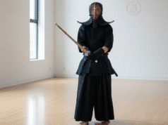 Kario kelias šiuolaikiniame pasaulyje: Daugiau nei vien agresija vyras treniruojasi kendo modernioje salėje