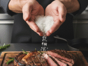 Druskos menas: esminė pamoka, kaip akimirksniu pagerinti kiekvieną patiekalą vyro rankos beria druską ant kepto steiko