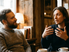 Veidrodžio principas: kaip paprastas atkartojimas padeda užmegzti ryšį? du vyrai kalbasi kavinėje, vienas gestikuliuoja ir pasakoja kitam