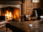 Konjakas – kilmingiausias pasaulio gėrimas: išsamus gidas džentelmenui konjako taurė pastatyta ant seno medinio stalo