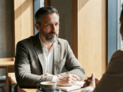 Derybų menas: kaip pasiekti savo tikslų be agresyvios konfrontacijos? vyras kavinėje kalbasi su partneriu ir derasi